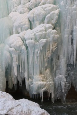 Donmuş şelale ve kayalardan sarkan buz saçakları.