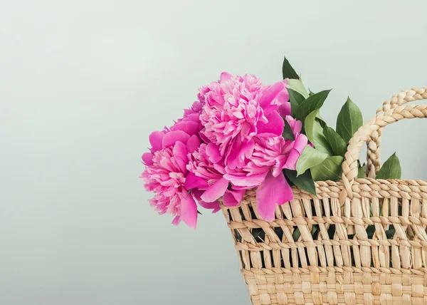 Pink peonies in straw basket with copy space. — Stock Photo, Image