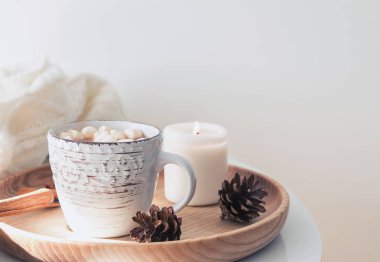 Sıcak kakao, mum, çam kozalakları ahşap tepsi.