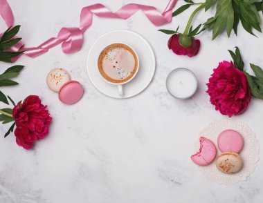 Kahve, pembe peonies ve macarons mermer masada