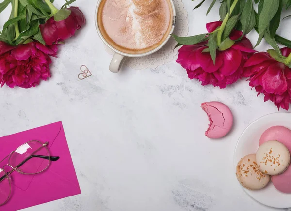 Coffee, pink peonies and macarons on the marble table backgrond — Stock Photo, Image