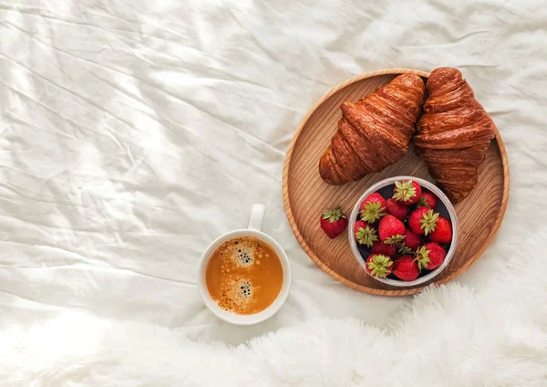 Café em croissants na cama branca na sala cheia de luz solar . — Fotografia de Stock