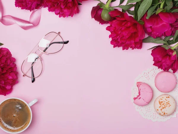 Peonies, kahve ve macarons pembe arka plan üzerinde