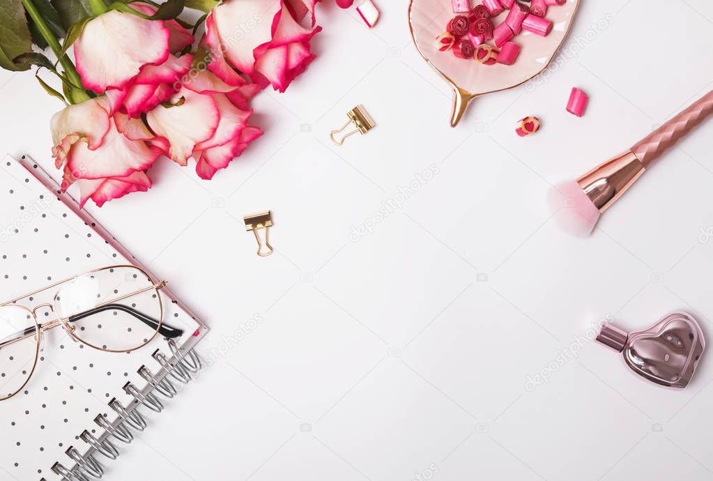 Roses and cute feminine accessories on the white table