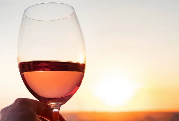 Um copo de vinho rosa no pôr do sol — Fotografia de Stock