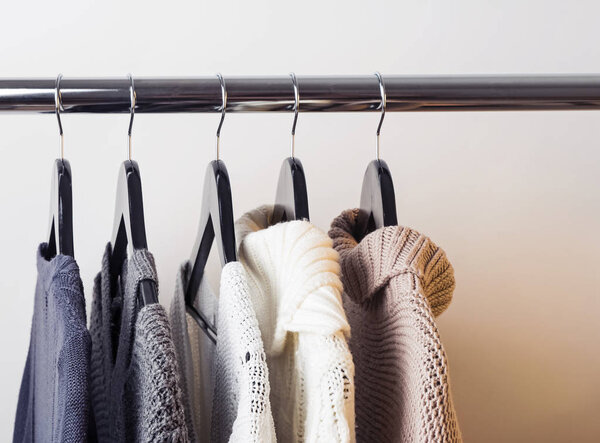 Вязаные свитера на вешалках
