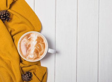 Sıcak cappuccino ve sarı kazak ile sonbahar natürmort.