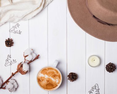 Kadınsı sonbahar ya da kış aksesuarları. Şapka, örgü kazak, kahve ve diğer küçük öğeler ahşap arka plan üzerinde.