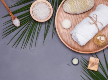 Spa natürmort kuru rush, beyaz havlu ve gri arka plan üzerinde tropic yaprakları ile