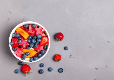 Gri arka plan üzerine bir kase lezzetli meyve salatası