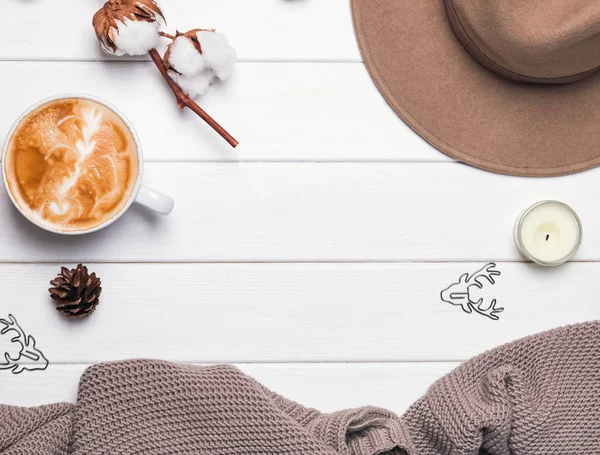 Kadınsı sonbahar ya da kış aksesuarları. Şapka, örgü kazak, kahve ve diğer küçük öğeler ahşap arka plan üzerinde.