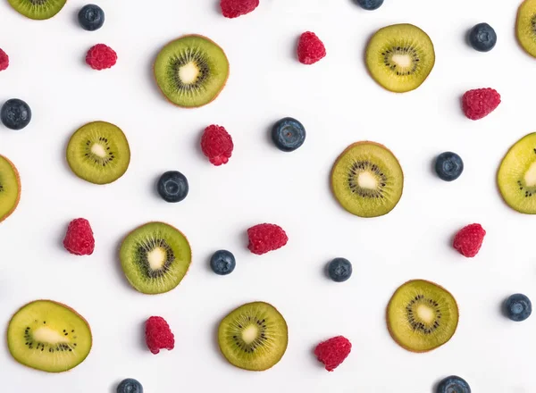 Creative fruit pattern with berries and kiwis