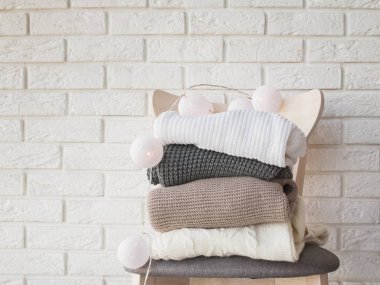 Örme kazak ve garland tuğla duvar arka ışıkları ile yığını