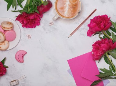 Kahve, pembe peonies ve macarons mermer zemin üzerine