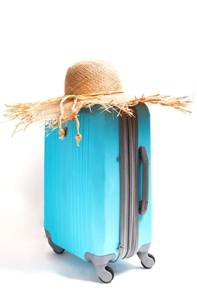 Niebieski walizkę i duże słomkowy kapelusz na nim. — Zdjęcie stockowe