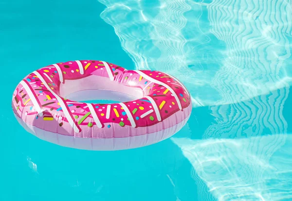 Bright donut shape inflatable ring floating in the swimming pool