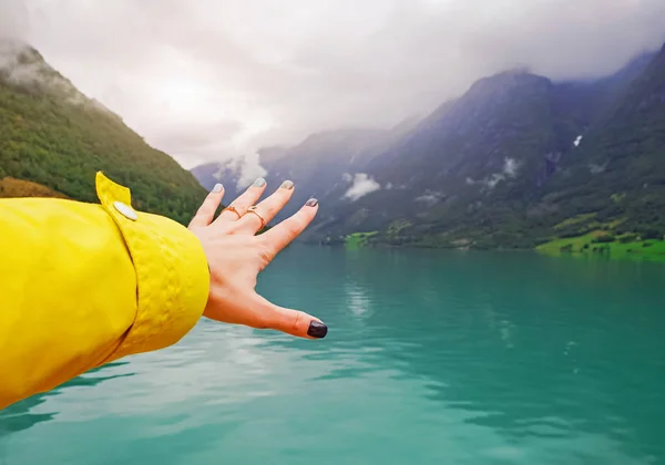 Γυναίκα που απλώνουν το χέρι κοντά στη λίμνη όμορφο βουνό. — Φωτογραφία Αρχείου