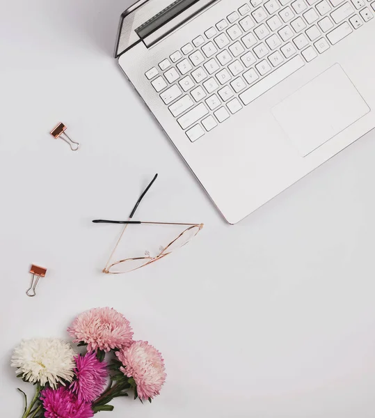 Laptop, flores e óculos no fundo branco . — Fotografia de Stock