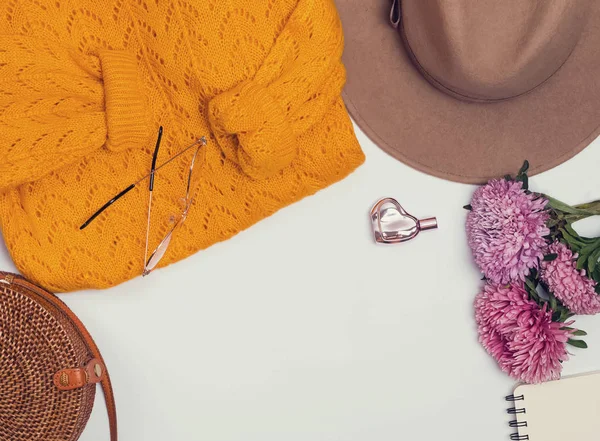 Sombrero de fieltro, suéter amarillo, bolso y flores, vista superior . — Foto de Stock