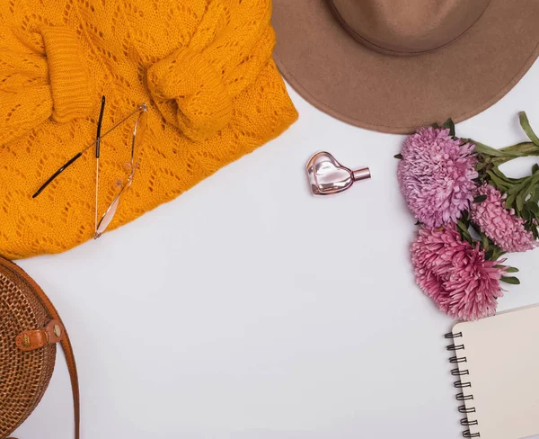 Accesorios femeninos de otoño: sombrero de fieltro, suéter amarillo, bolso y flores . — Foto de Stock