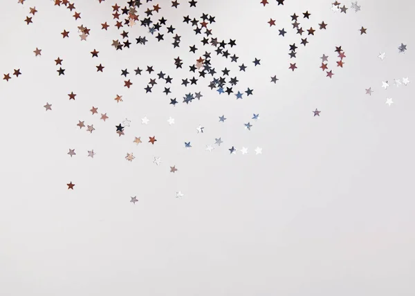 Блестящие конфетти в форме звезды серебряного цвета на белом — стоковое фото