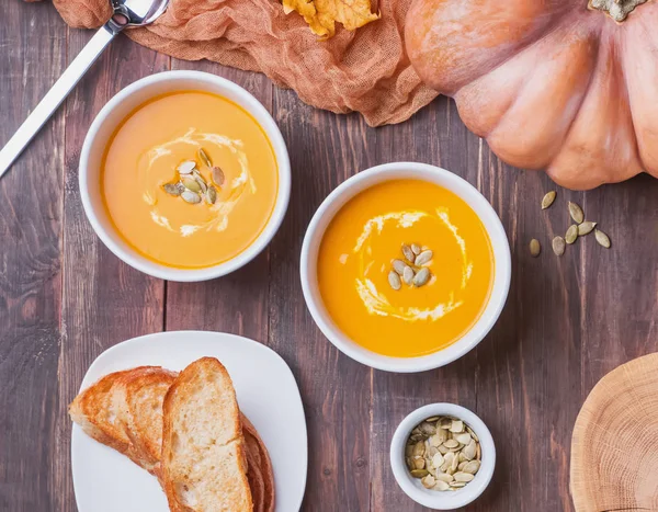 Duas taças de sopa de abóbora caseira deliciosa com creme — Fotografia de Stock