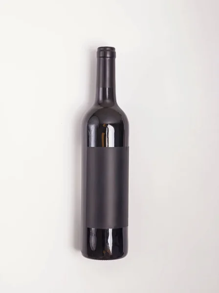 Bottiglia di vino rosso distesa sul fondo bianco — Foto Stock