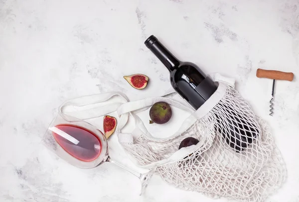 Butelka wina, szkła i fig na marmurowym stoliku — Zdjęcie stockowe
