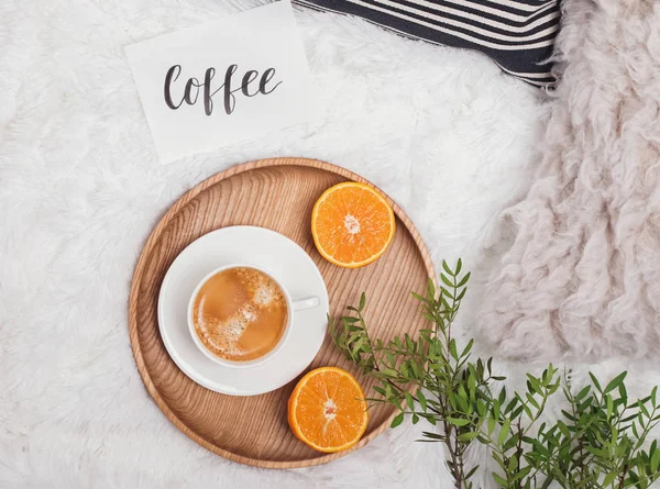 Confortable plat avec café, branches vertes et oranges sur le lit . — Photo
