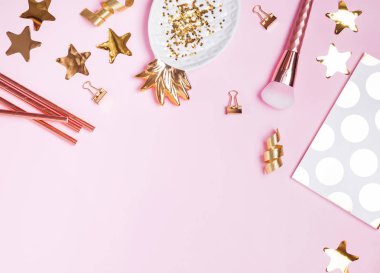 Altın dekorasyonu ve pembe bir arka plan üzerinde kadınsı aksesuarları