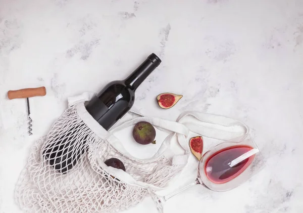 Garrafa de vinho, vidro e figos na mesa de mármore — Fotografia de Stock