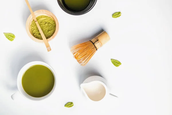 Prášek, zelený čaj a mléko na bílém pozadí, pohled shora — Stock fotografie
