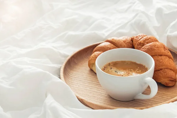 Kahve ve kruvasan ile yatakta kahvaltı — Stok fotoğraf