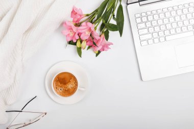 Kahve, çiçek ve beyaz masa üstünde laptop