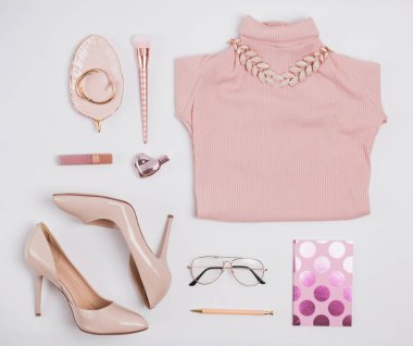 Beyaz arka plan üzerinde şık soluk pembe kadınsı aksesuarları.