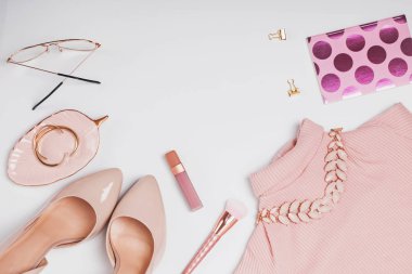 Beyaz arka plan üzerinde şık soluk pembe kadınsı aksesuarları.