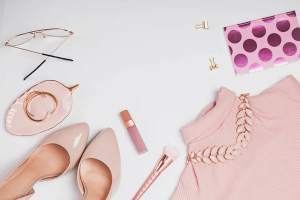 Elegantes accesorios femeninos de color rosa pálido sobre el fondo blanco . — Foto de Stock