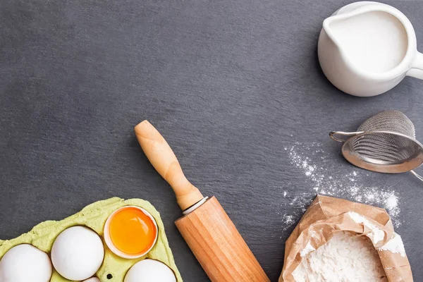 Cozimento ingredientes e ferramentas no fundo de pedra preta — Fotografia de Stock