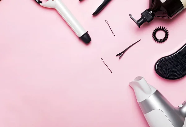 Artículos y productos para el peinado y cuidado del cabello sobre fondo rosa — Foto de Stock