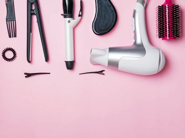Artículos y productos para el peinado y cuidado del cabello sobre fondo rosa — Foto de Stock