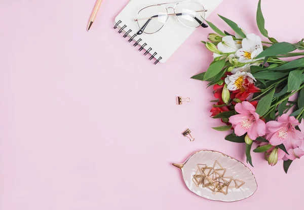 Bloemen, Kladblok en briefpapier op roze achtergrond. — Stockfoto