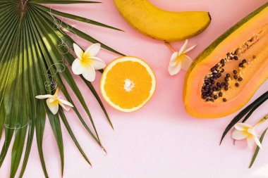 Palmiye yaprakları, papaya ve plumeria çiçekleri ile yaratıcı bileşim.