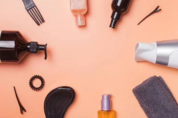 Productos para el cuidado del cabello y artículos de peinado sobre fondo naranja — Foto de Stock