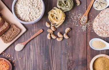 Un, ekmek, makarna ve mercimek ve diğer malzemeler ahşap masa üzerinde kuru.
