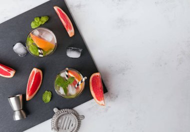 Gözlük içkiyle bar ekipmanları ve greyfurt siyah arduvaz taş parçalarını görünümü top.