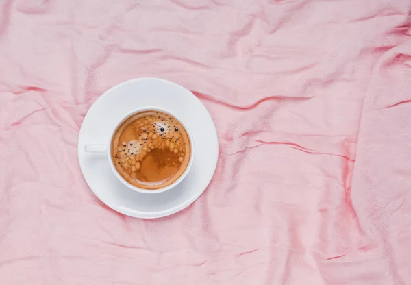 Kopp kaffe på pastell rosa tyget. Minimalistisk komposition. — Stockfoto