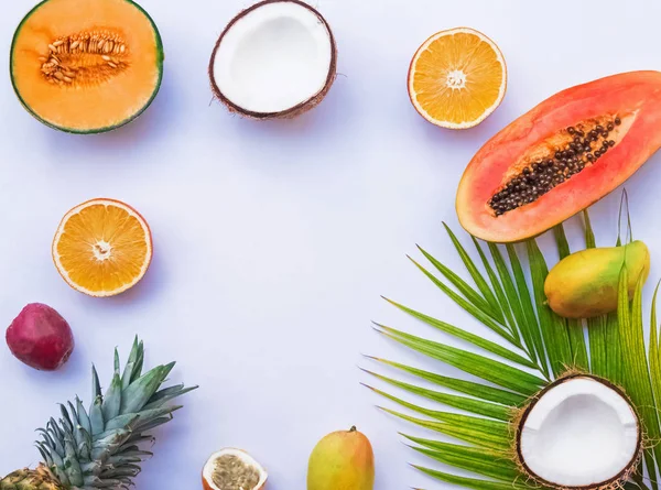 Creatieve frame met tropische vruchten en palm blad op de witte achtergrond, — Stockfoto