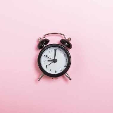 Pastel pembe arka plan üzerinde izole küçük çalar saat