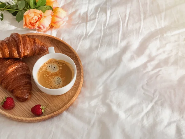Café e croissants deliciosos na roupa de cama branca com espaço de cópia — Fotografia de Stock