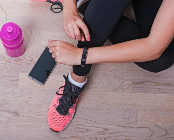 Kvinnan som kontrollerar hennes träningsräknare innan löpning eller annan sport — Stockfoto